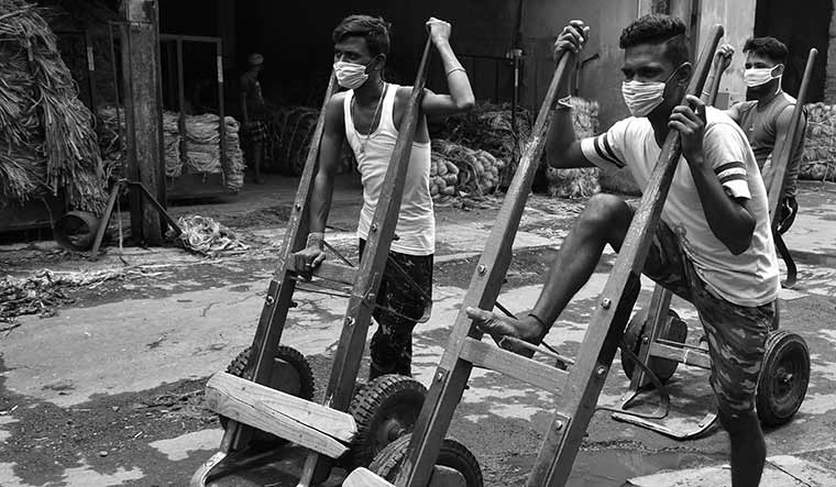 Labourers await their turn to carry raw jute to the factory.