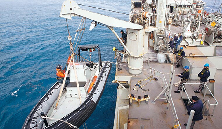 Tricky job: An inflatable boat being launched from HMAS Success during the search for the suspected remains of MH370 | AP 