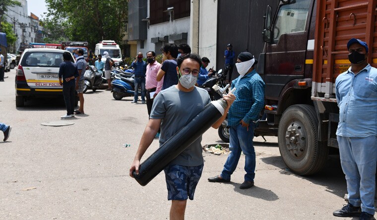 Gasping for air: A Delhi resident carries an oxygen cylinder for refilling at Naraina Industrial Area in April. The Delhi High Court had pulled up the Centre over the oxygen crisis in the capital | Sanjay Ahlawat
