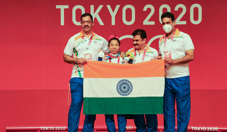 Team work: Chanu celebrates with coach Vijay Sharma (to her right) after receiving her medal | PTI