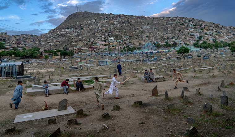 Bat, ball and belief: Afghan boys play cricket in a cemetery in Kabul | AP