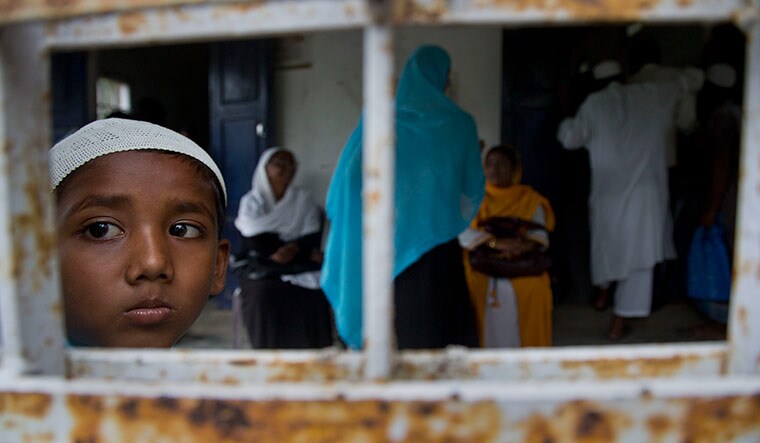 Frozen lives: A boy looks out of a window as villagers wait to check their names in the NRC list in Morigaon district of Assam on August 31 | AP