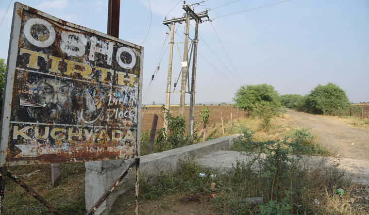 A rusty signboard featuring Osho on the main road leading to the village | Mujeeb Faruqui