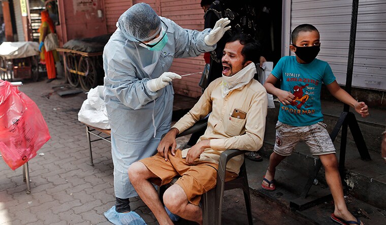 A doctor wearing a hazmat suit and a mask, conducts a swab test on a man, to check if he has the coronavirus, during a nationwide lockdown in India to slow the spread of COVID-19, in Dharavi, one of Asia's largest slums, during the coronavirus disease outbreak, in Mumbai, India, April 9, 2020. REUTERS/Francis Mascarenhas     SEARCH "CORONAVIRUS MUMBAI SLUM" FOR THIS STORY. SEARCH "WIDER IMAGE" FOR ALL STORIES.