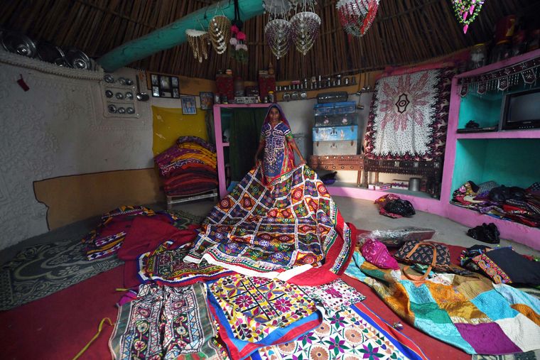A villager displays a variety of embroidery works.