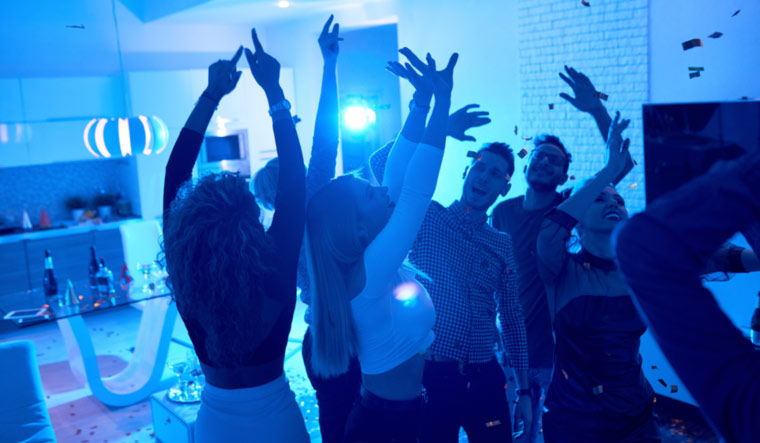 blue-light-young-people-dancing-under-confetti-in-private-house-closed-party