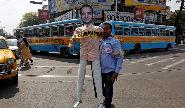 A demonstrator holds an effigy depicting billionaire jeweller Nirav Modi during a protest in Kolkata | Reuters
