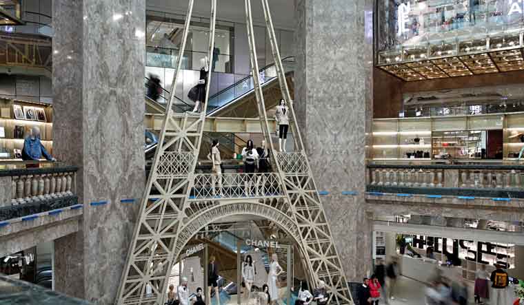 Shoppers browse as Chanel luxury corner sales stand sits on the ground floor of the Galeries Lafayette department store on the Champs-Elysees avenue in Paris | Reuters