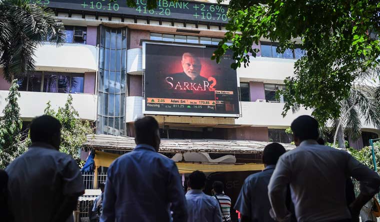 People look at the screen on BSE building as the Sensex soars on the vote counting day on Thursday in Mumbai | PTI