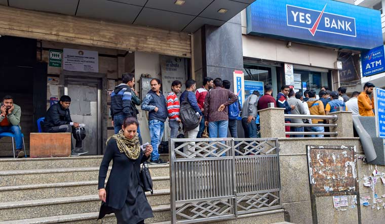 Account holders stand in a queue to withdraw money from YES Bank, at Krishna Nagar in New Delhi | PTI