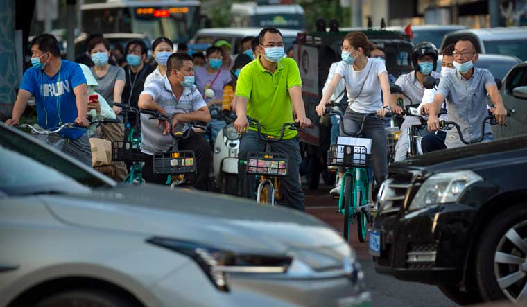 China-beijing-cyclists-masks-economy-AP