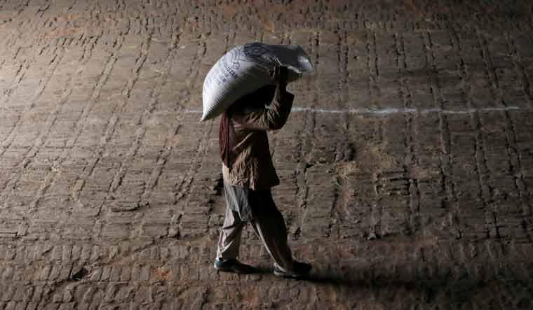 FILE PHOTO: A worker carries a sack of sugar on his shoulders at a depot in Peshawar, Pakistan January 23, 2019. REUTERS/Fayaz Aziz/File Photo
