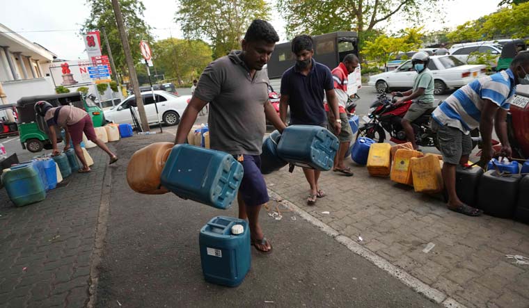 Sri Lankans gather at a fuel station to buy diesel before the beginning of curfew in Colombo | AP