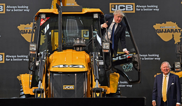 Britain's Prime Minister Boris Johnson stands on a JCB machine during his visit to the new JCB Factory in Vadodara | AFP