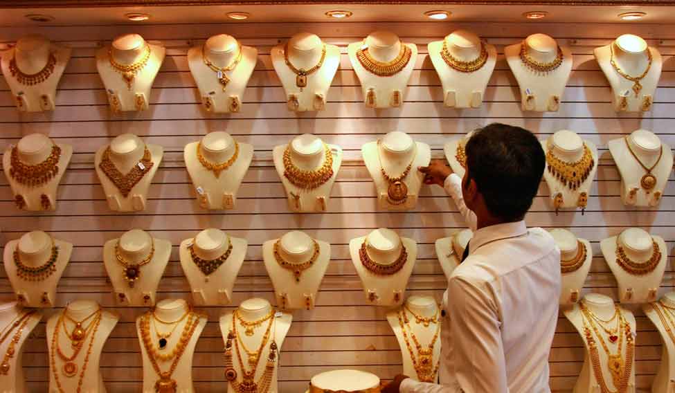 A salesman arranges a gold necklace inside a gold jewellery showroom in the southern Indian city of Kochi April 16, 2012. Indian gold futures are likely to extend losses this week, falling below a one-week low touched on Monday, hurt by a firm dollar overseas, although a revival in physical demand ahead of key festival could limit the downside, analysts said. REUTERS/Sivaram V (INDIA - Tags: BUSINESS COMMODITIES) - RTR30T4Q