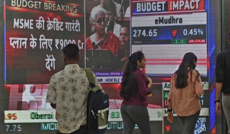 People walk past a telecast of Finance Minister Nirmala Sitharaman presenting the budget, inside the BSE building in Mumbai | Amey Mansabdar