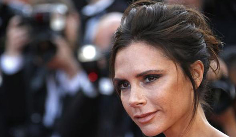 Fashion designer, model and singer Victoria Beckham poses on the red carpet as she arrives for the opening ceremony and the screening of the film 