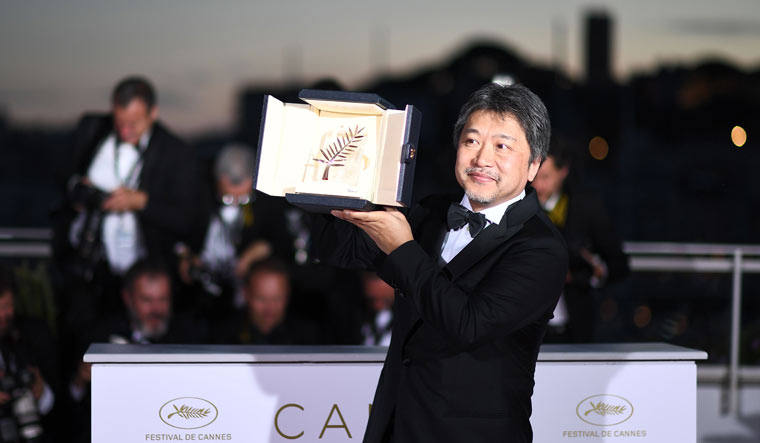 Japanese director Hirokazu Kore-Eda poses with the trophy after he won the Palme d'Or for the film 