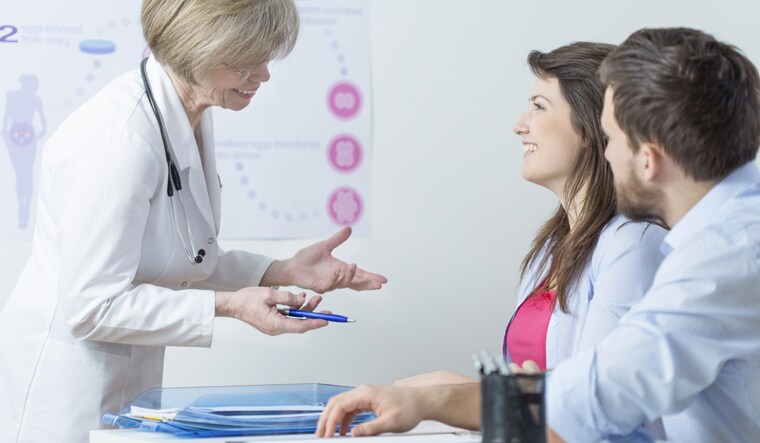 infertility-Young-happy-couple-talking-about-in-vitro-result-with-doctor-shut