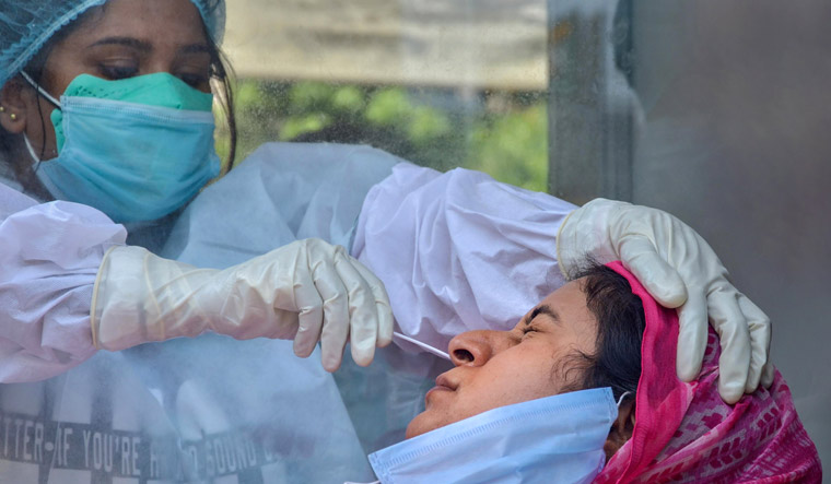 A medic collects samples from a women for COVID-19 swab tests at Civil Hospital in Amritsar | PTI