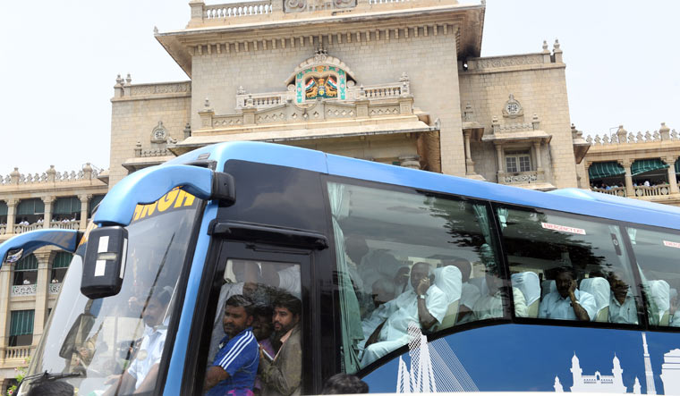 Congress MLAs, sitting in a bus, leave the Vidhana Soudha after staging a protest dharna against the swearing-in of B.S. Yeddyurappa as Karnataka chief minister, in Bengaluru on Thursday | Bhanu Prakash Chandra