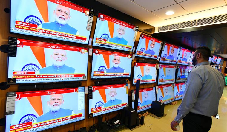 A man watching television as Prime Minister Narendra Modi addresses the nation in the wake of novel coronavirus scare, in New Delhi | Sanjay Ahlawat
