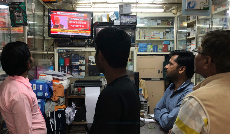 People watch on television Prime Minister Narendra Modi addressing the nation amid concerns of coronavirus outbreak in New Delhi | AP