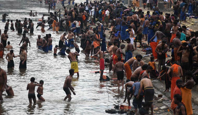 Devotees bathing in the Pamba river before the start of the trek to the Sabarimala temple | AFP