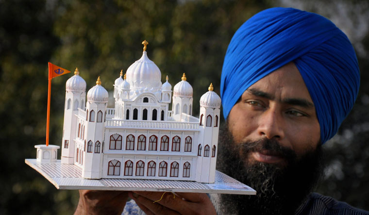 Paper artist Gurpreet Singh shows his creation, a paper model of Guru Nanak Dev Ji's gurudwara (Kartarpur Sahib) in Pakistan, in Amritsar [Representative image/PTI]