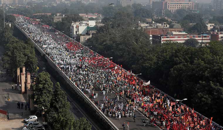 Farmers march towards the parliament house during a rally to protest soaring farm operating costs and plunging prices of their produce, in New Delhi | Reuters