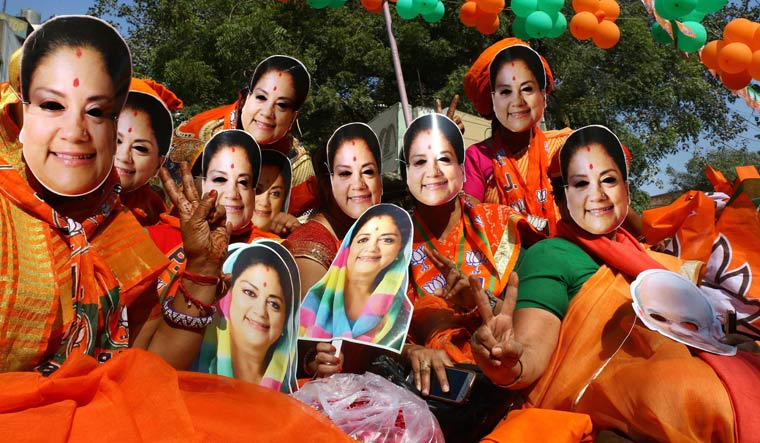 BJP supporters wear masks of Rajasthan Chief Minister Vasundhara Raje at an election rally, in Ajmer | PTI