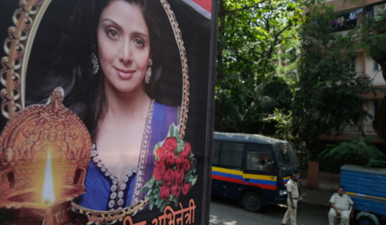 Policemen guard near a picture of Indian actress Sridevi residence