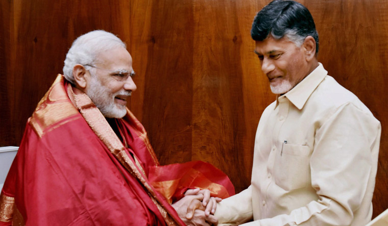 Prime Minister Narendra Modi is presented with a shawl by TDP president and Andhra Pradesh Chief Minister Chandrababu Naidu