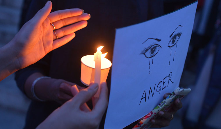 Rights activist stage a candle light vigil in Bengaluru in solidarity with the recent rape cases in the country | AFP