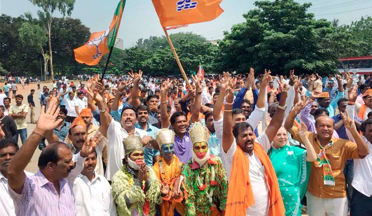 BJP workers celebrate the party's lead in over hundred Assembly constituencies, as the counting of votes is in progress, in Bengaluru | PTI
