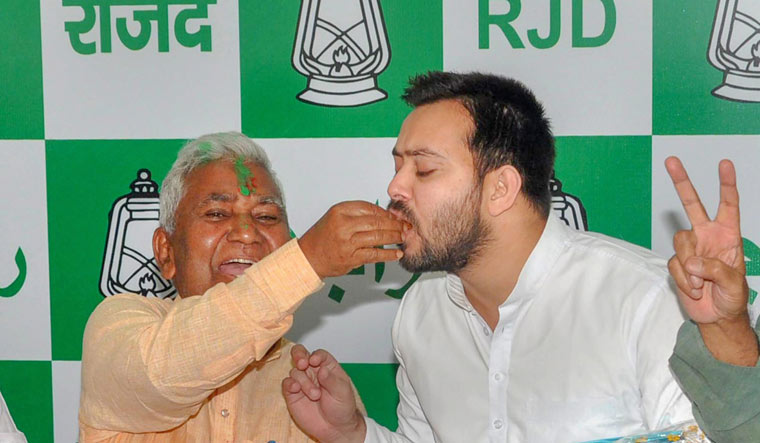 RJD leader Tejashwi Yadav is offered sweets by party state president Ramchandra Purbey to celebrate party's win in Jokihat Assembly by-election | PTI