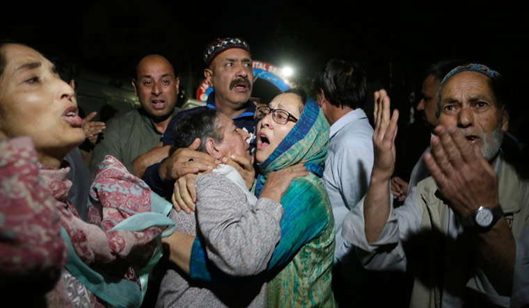 Relatives and friends of Shujaat Bukhari, who was shot dead Thursday evening, cry inside a police control room in Srinagar | AP