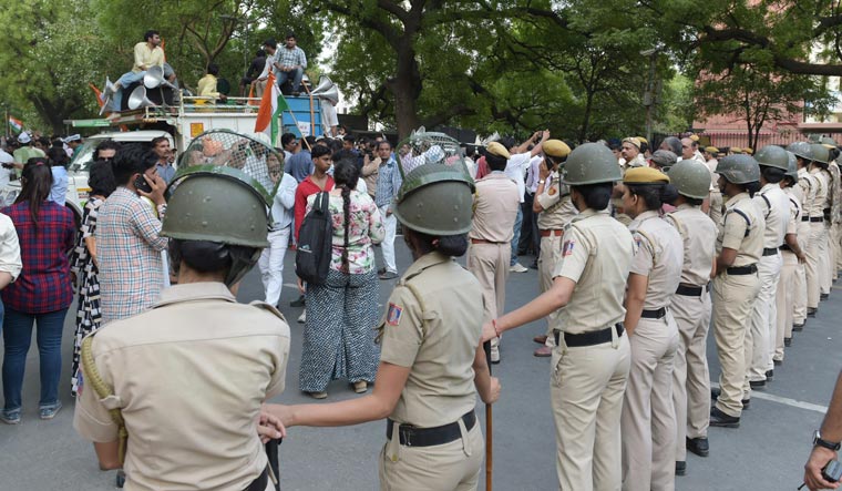 Delhi Police personnel stand guard as AAP workers march in support of Delhi Chief Minister Arvind Kejriwal's dharna at LG's office in New Delhi on Sunday | PTI
