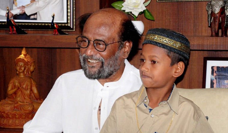 Rajinikanth meets young boy Mohammed Yaseen who was rewarded for his honesty at formers residence, in Chennai | PTI