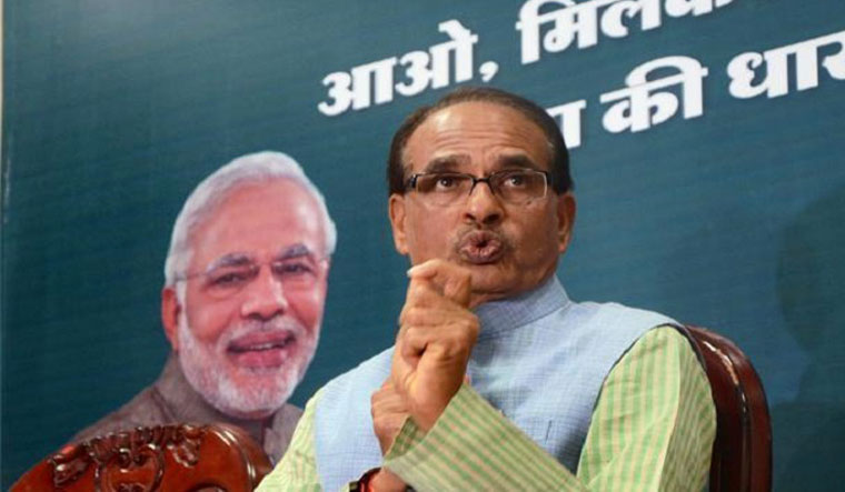[FILE] Madhya Pradesh Chief Minister Shivraj Singh Chouhan. A hoarding with Prime Minister Narendra Modi's face is also seen on the background | PTI