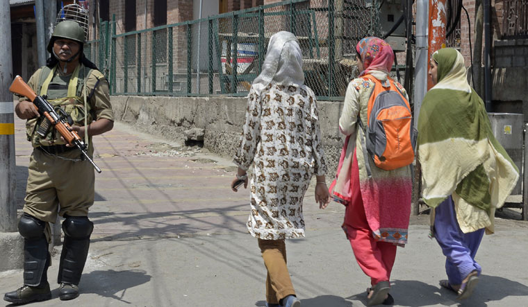 A paramilitary jawan patrols a deserted street in Srinagar during a separatist shutdown a day before the second death anniversary of Burhan Wani | AFP