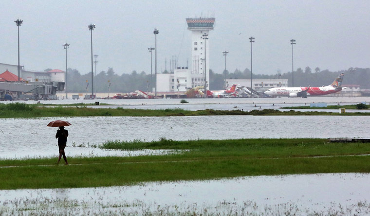 A man walks inside the flooded Cochin international airport | Reuters