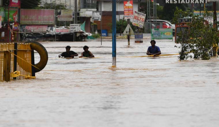 People wading through the flooded road at Athani junction on Kochi-Thrissur National Highway | Manorama