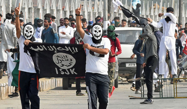 Kashmiri protestors hold an Islamic State flag during clashes with Indian government forces after Eid prayers in downtown Srinagar on Wednesday