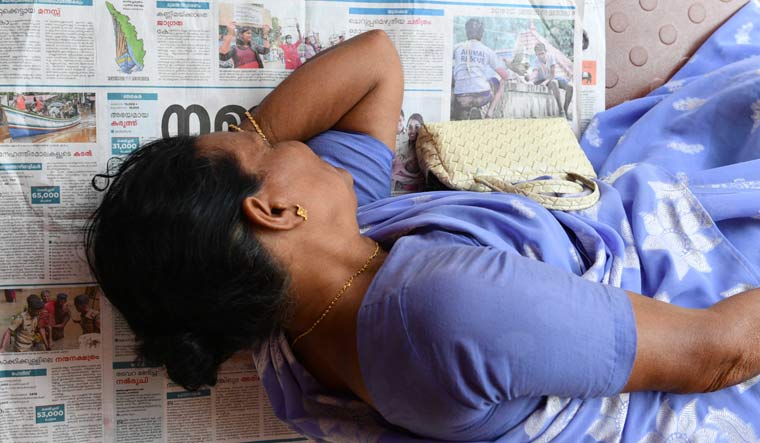 Ammukutty, a resident of Neendoor, sleeps on a sheet of a newspaper at a relief camp in Paravoor near Kochi | Josekutty Panackal