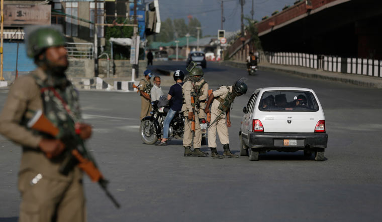 Security personnel interrogate a civilian during a strike in Srinagar | AP