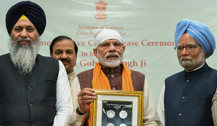 Prime Minister Narendra Modi releases a commemorative coin to mark the birth anniversary of Guru Gobind Singh Ji, the tenth guru of Sikhs, in New Delhi. Former prime minister Manmohan Singh and Minister of State for Culture (I/C) and Environment, Forest and Climate Change Mahesh Sharma are also seen | PTI