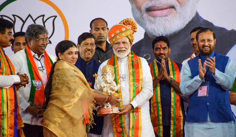 Prime Minister Narendra Modi recieves a memento during an election campaign rally ahead of Maharashtra Assembly polls, in Pune | PTI