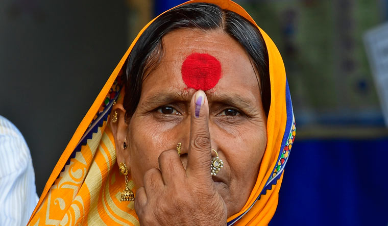 A voter shows her inked finger at a polling booth in Mumbai | Amey Mansabdar