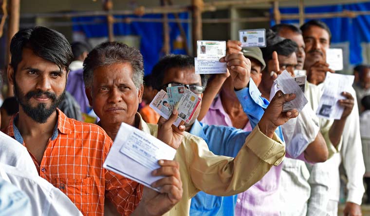 Voters showing their identity cards at a polling station in Mumbai | Amey Mansabdar